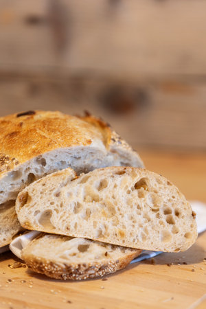 Homemade freshly bread and slices on kitchen table. Sourdough wheat rye loaf with seeds close-up viewの写真素材