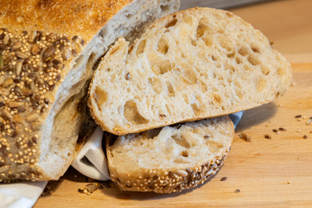 Homemade freshly bread and slices on kitchen table. Sourdough wheat rye loaf with seeds close-up viewの写真素材