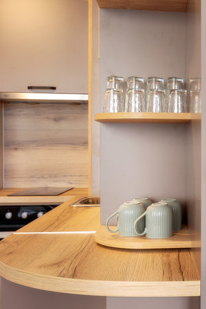 Ceramic tea mugs and glasses on the shelves side by side