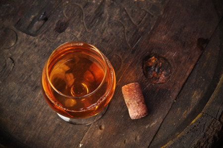 cuban cigars and cognac in glass, bottles and barrel on a wooden backgroundの写真素材