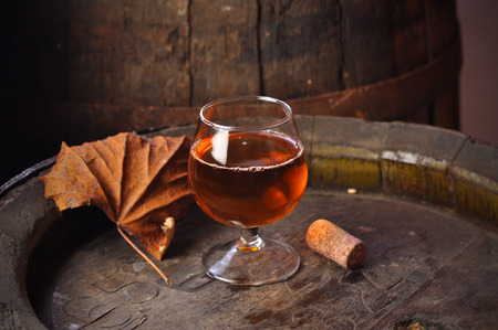 cuban cigars and cognac in glass, bottles and barrel on a wooden backgroundの写真素材