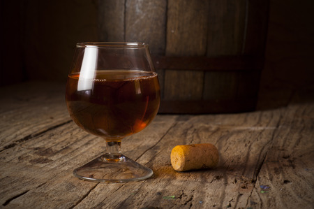 cuban cigars and cognac in glass, bottles and barrel on a wooden backgroundの写真素材