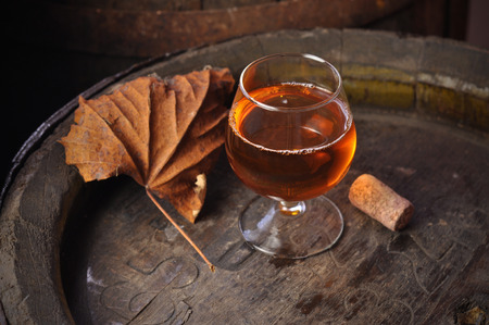 cuban cigars and cognac in glass, bottles and barrel on a wooden backgroundの写真素材