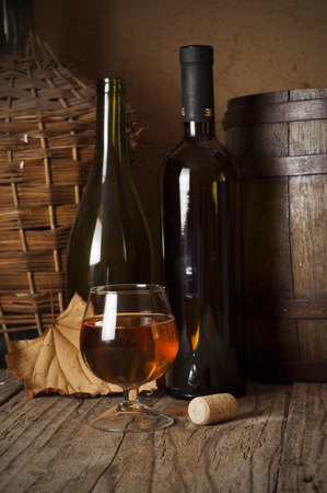 cuban cigars and cognac in glass, bottles and barrel on a wooden backgroundの写真素材