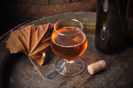 cuban cigars and cognac in glass, bottles and barrel on a wooden backgroundの写真素材
