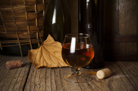cuban cigars and cognac in glass, bottles and barrel on a wooden backgroundの写真素材