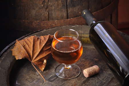 cuban cigars and cognac in glass, bottles and barrel on a wooden backgroundの写真素材