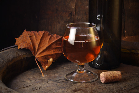 cuban cigars and cognac in glass, bottles and barrel on a wooden backgroundの写真素材