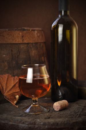 cuban cigars and cognac in glass, bottles and barrel on a wooden backgroundの写真素材