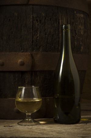 Glass white wine and bunch grapes on background of woodenの写真素材