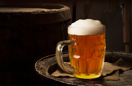 Still life: old wooden pin of beer, glass of beer and wheat on the table in the cellar.の写真素材