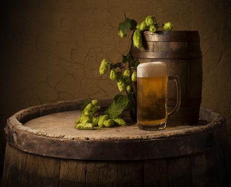 Still life: old wooden pin of beer, glass of beer and wheat on the table in the cellar.の写真素材