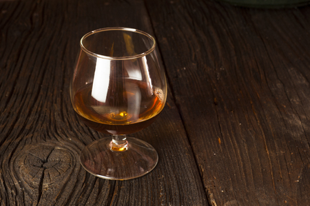 Glasses of brandy in cellar with old barrelsの写真素材