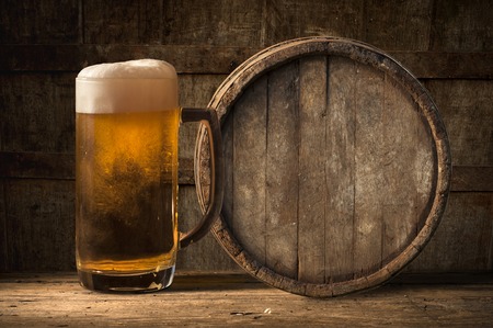Beer barrel with beer glass on table on wooden backgroundの写真素材
