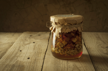 honeycomb on frame with fresh honey in a vase on wooden table.の写真素材