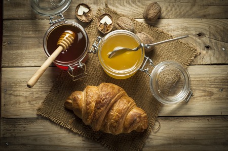 Croissants with honey in a rustic styleの写真素材