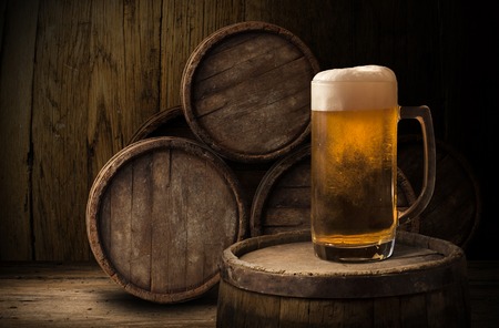 Beer barrel with beer glasses on a wooden table. The dark background.の写真素材