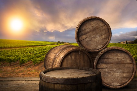 Red wine with barrel on vineyard in green Tuscany, Italyの写真素材