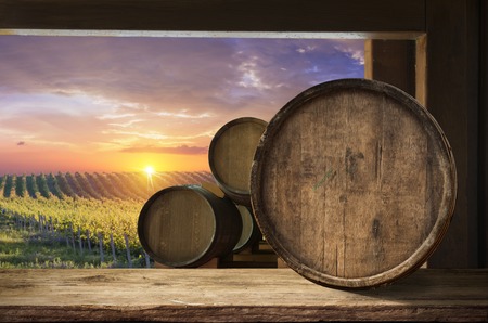 Red wine with barrel on vineyard in green Tuscany, Italyの写真素材