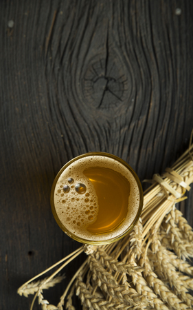 Beer, green hops and malt on a stone surface.の写真素材