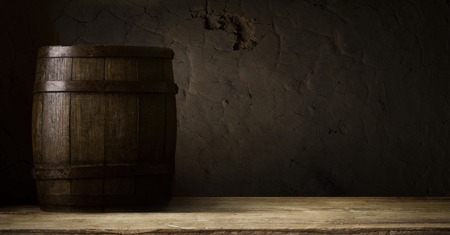 background of barrel and worn old table of woodの写真素材