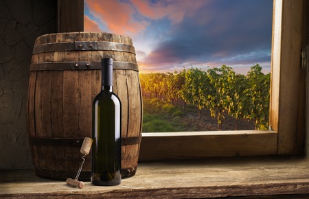 Red wine with barrel on vineyard in green Tuscany, Italyの写真素材