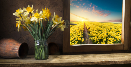 Old wood table next to window with white flowerの写真素材