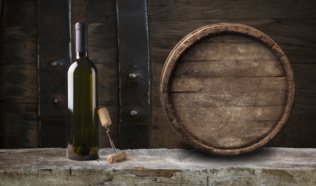 Tasty wine on wooden barrel on grape plantation backgroundの写真素材