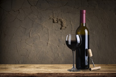 red wine bottle and wine glass on wodden barrelの写真素材