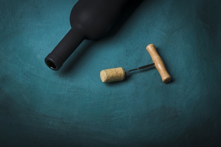 Pouring red wine into the glass against wooden backgroundの写真素材