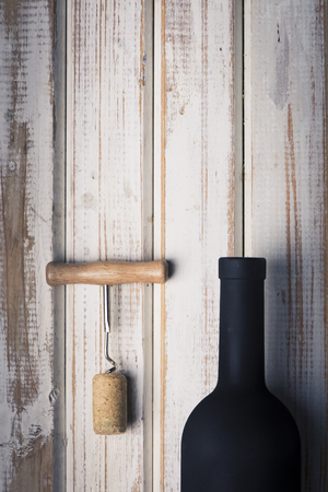 Pouring red wine into the glass against wooden backgroundの写真素材