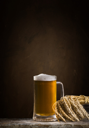 Beer in mug on wooden table near brick wallの写真素材