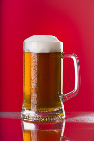 Light beer mug against the backdrop of the bar shelfの写真素材