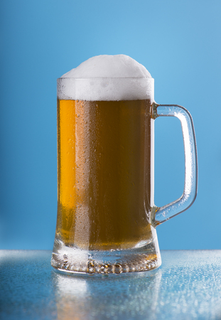 Light beer mug against the backdrop of the bar shelfの写真素材