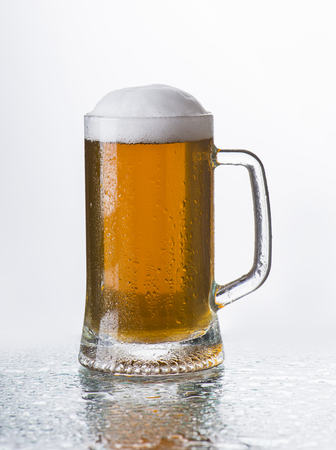 Light beer mug against the backdrop of the bar shelfの写真素材