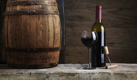 Red wine with barrel on vineyard in green Tuscany, Italy