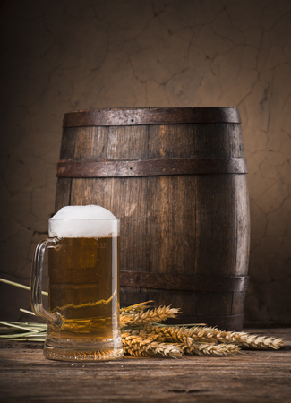 Beer barrel with beer glass on table on wooden backgroundの写真素材