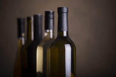 Bottles of red wine on a wooden shelfの写真素材