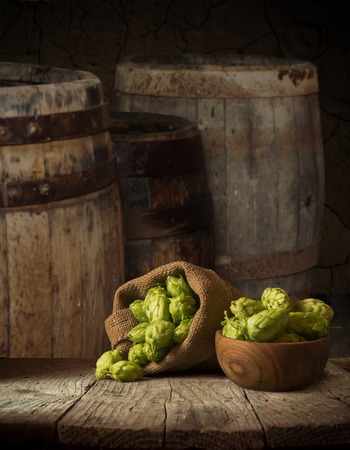 Oktoberfest beer barrel and beer glasses with wheat and hops on wooden tableの写真素材