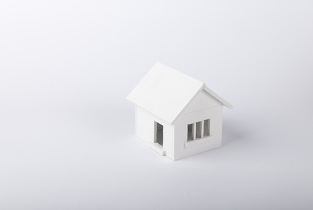 House in winter - heating system concept and cold snowy weather with model of a house wearing a knitted capの写真素材