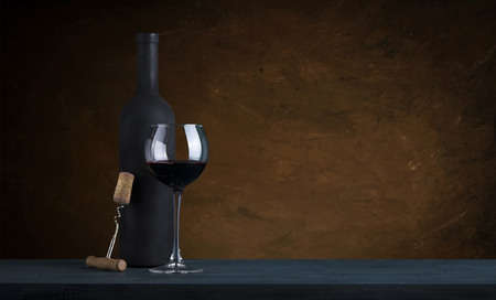 red wine bottle and wine glass on wodden barrelの写真素材