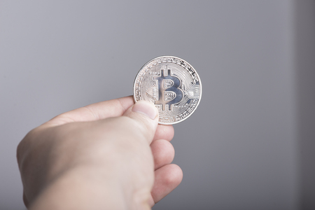 Two symbolic coins of bitcoin on banknotes of one hundred dollars. Exchange bitcoin cash for a dollarの写真素材