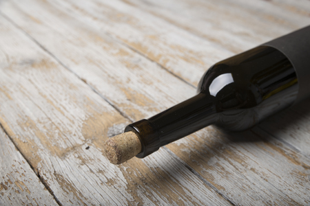 Bottle of red wine with a corkscrew. On a black wooden backgroundの写真素材