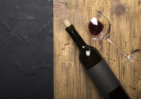 Bottle of red wine with a corkscrew. On a black wooden backgroundの写真素材