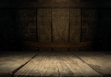 background of barrel and worn old table of wood.の写真素材