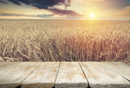 Wheat field with wood planks. Empty tabletop. Table with wheat.Beautiful Nature Sunset Landscape. Rural Scenery with golden wheat. Agriculture background with Harvest.の写真素材