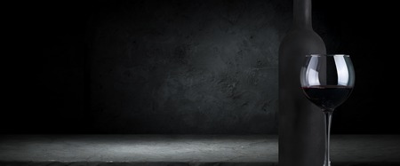 Red wine glasses and bottle on stone background. Top view with copy space.の写真素材