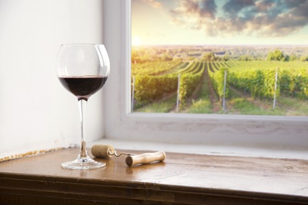 red wine bottle and wine glass on wodden barrelの写真素材