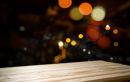Festive wooden background with glittering bokeh lights, illuminated by a spotlight, ideal for Christmas or other occasionsの写真素材