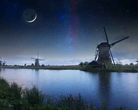 Night field of tulips and windmill. Landscape with stars and flowers. Traditional Holland viewの写真素材